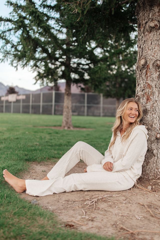 Kiera sitting under a tree, laughing